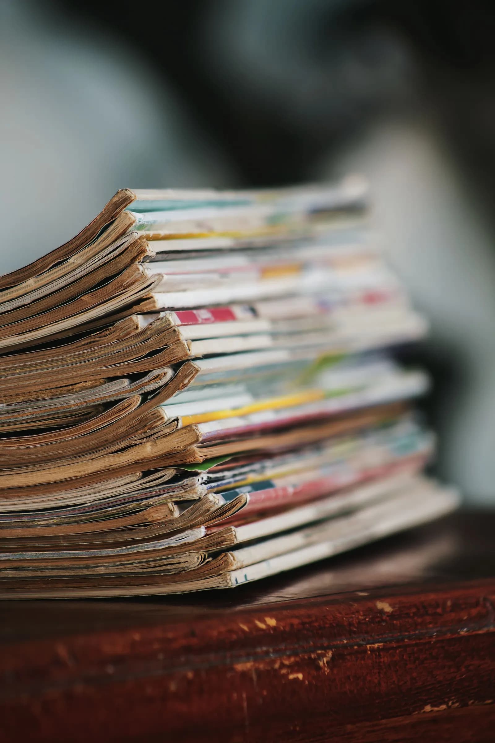 A stack of well-thumbed magazines on a table